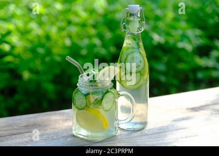 Entgiften Sie Wasser mit Gurke, Limette und Minze in Glas und Flasche. Gesunde Lebensweise, Sommer Drink Konzept. Stockfoto