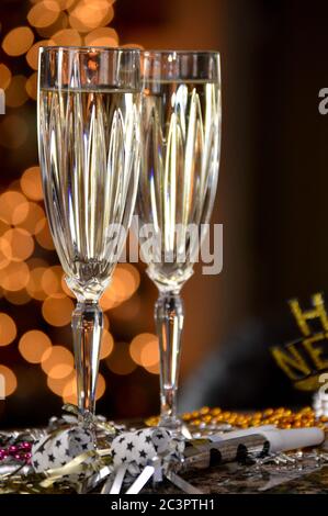 Silvesterfeier für zwei Personen mit Sektflöten und Weihnachtsbeleuchtung im Hintergrund Stockfoto