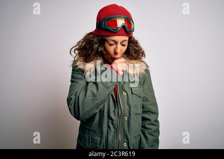 Skifahrerin mittleren Alters Frau trägt Schnee Sportbekleidung und Skibrille über weißem Hintergrund Gefühl unwohl und Husten als Symptom für Kälte oder Bronchitis. Er Stockfoto