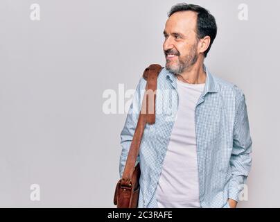 Mittelalter gut aussehende Geschäftsmann tragen Ledertasche über isoliert weißen Hintergrund suchen zur Seite, entspannen Profil Pose mit natürlichen Gesicht und zuversichtlich Stockfoto