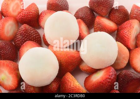 Erdbeer-Eis-Mochi und frische RohErdbeeren auf rosa Hintergrund Stockfoto