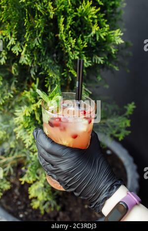 Cranberry Limonade auf der Fächerzone in den Händen eines Kellners auf dem Cob Stockfoto