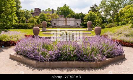 Der Rasen und die Gärten im Mellon Park mit einem Steinbrunnen im Hintergrund an einem sonnigen Sommertag, Pittsburgh, Pennsylvania, USA Stockfoto