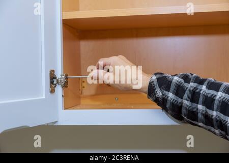 Zimmermann Einstellung einer Küchenschrank Metallscharniere für Türen Stockfoto