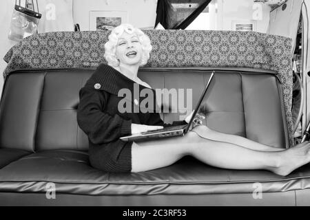 Moderne nehmen Marilyn, Retro-Stile, Vintage-Stile, Periode Stile. Marilyn Monroe Satire, frustriert mit ihrem Laptop in ihrem chaotischen Haus Stockfoto