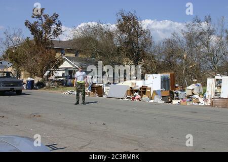 BILOXI, VEREINIGTE STAATEN - Sep 07, 2005: Airman schaut auf Trümmer, die nach dem Hurrikan Katrina gesammelt wurden. Stockfoto