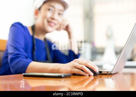 Chefin Geschäftsfrau lächelt bei der Arbeit am Laptop zu Hause an der Kamera. Stockfoto