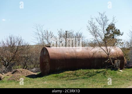 Zwei alte verlassene rostige Fässer liegen im Freien auf dem Gras. Stockfoto