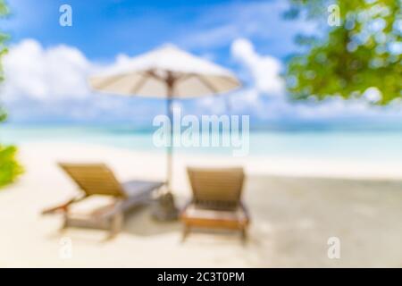 Sommer exotischer Sandstrand mit verschwommenen Palmen und Meer im Hintergrund. Stockfoto