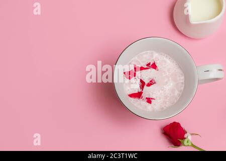 Tasse Rose Cardamom Almond Moon Milk (rosa Mondmilch) auf pastellrosa Hintergrund. Overhead-Ansicht mit Platz für Text Stockfoto