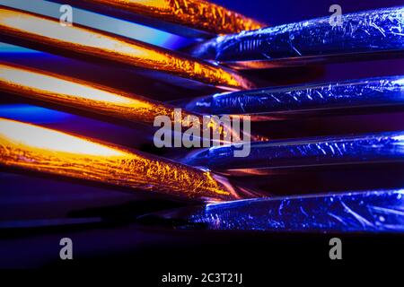 Zwei Gabeln in bunten Beleuchtung Makro-Aufnahme schaffen eine abstrakte Komposition. Bild ist als Hintergrund geeignet. Stockfoto