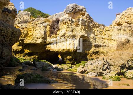 Eine einsame Bucht entlang des Strandes Oura Praia an der Algarve Portugal in der Nähe von Albuferia, die verwitterte Felsen und Winderosion zeigt. Stockfoto