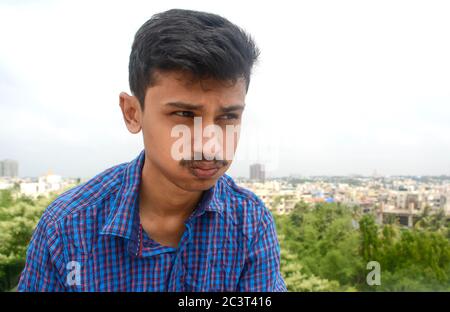 Portrait von schönen jungen Teenager-Mann in tiefen Gedanken über seine Zukunft auf Himmel Hintergrund. Stockfoto