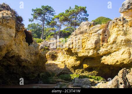 Eine einsame Bucht entlang des Strandes Oura Praia an der Algarve Portugal in der Nähe von Albuferia, die verwitterte Felsen und Winderosion zeigt. Stockfoto