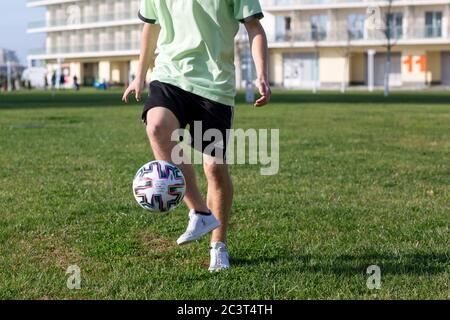 Fußballfreestyle. Junger Mann übt mit Fußball. Spieler, der die Grundtricks mit dem Ball trainiert. Stockfoto