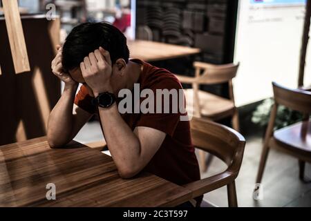 Junge asiatische Restaurant Shop Besitzer gestresst und Kopf nach unten, Angst vor dem Bankrott von Covid-19 Coronavirus Pandemie Ausbruch. Stockfoto