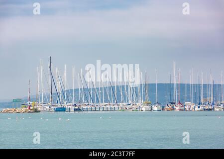 Yachten bei Sonnenuntergang, viele Segelboote im Hafen. Weiße Yachten auf einem Anker im Hafen Stockfoto