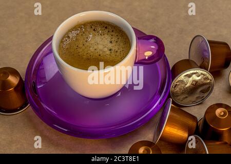 Tasse Kaffee auf beigem Hintergrund mit Kaffeekapseln. Süßes Essen. Gesundes Frühstück. Stockfoto