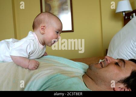 Vater spielt mit Baby im Bett, Kanarische Inseln, Spanien Stockfoto