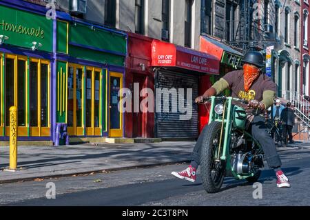 Mann, der ein Triumph Motorrad in East Village, Alphabet Stadt Notfall staris Feuerlandschaft. New York. Alphabet City Apartments. Haus mit Stockfoto