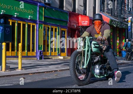 Mann, der ein Triumph Motorrad in East Village, Alphabet Stadt Notfall staris Feuerlandschaft. New York. Alphabet City Apartments. Haus mit Stockfoto