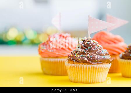 Stand mit Geburtstag Cupcakes und Party-Ballons auf farbigem Hintergrund. Leerzeichen für Text Stockfoto