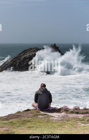 Ein Tourist, der die dramatische Aussicht von Pentire Point East an der Küste von Newquay in Cornwall genießt. Stockfoto