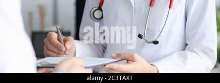 Ein weiblicher Arzt meldet die Patientenkarte mit der Diagnose Stockfoto