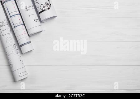 Architekt hat sich von oben gesehen. Architekturprojekt, Blaupausen, Blaupause Rollen auf Holzschreibtisch. Hintergrund der Bauarbeiten. Engineering-Tools. Kopieren Stockfoto