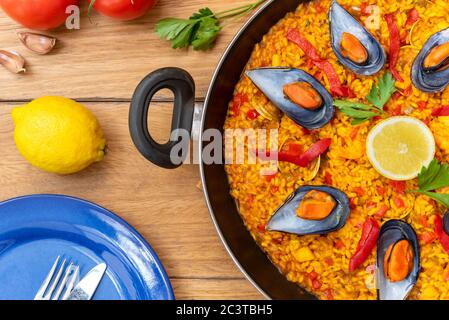 Spanische Paella auf Pfanne auf Holzboden Stockfoto
