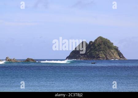 Boot und Wellen am Mawun Strand Lombok, Indonesien. Kuta Lombok ist ein exotisches Paradies auf der indonesischen Insel, mit schönen weißen Sandstränden und Weinen Stockfoto