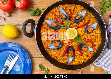 Spanische Paella auf Pfanne auf Holzboden Stockfoto