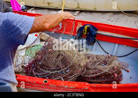 Fischer ist stapeln Fischernetz und bereiten sich auf seine nächste Angeln. Stockfoto