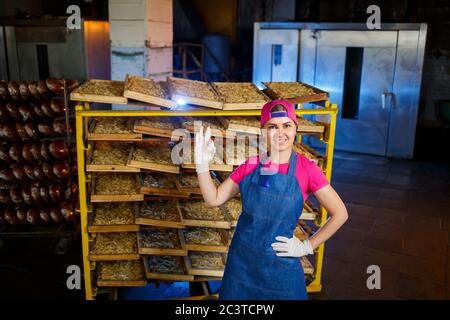 Arbeiter mit einer Schachtel Nudeln. Das Mädchen arbeitet an der Herstellung von Spaghetti. Nudeln machen. Pasta-Fabrik. Stockfoto