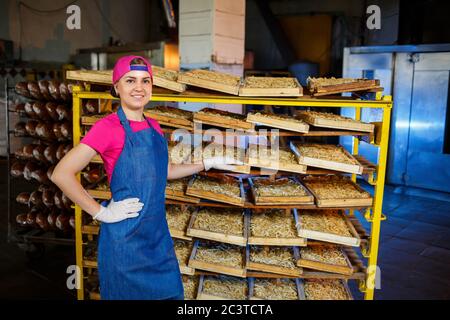 Arbeiter mit einer Schachtel Nudeln. Das Mädchen arbeitet an der Herstellung von Spaghetti. Nudeln machen. Pasta-Fabrik. Stockfoto