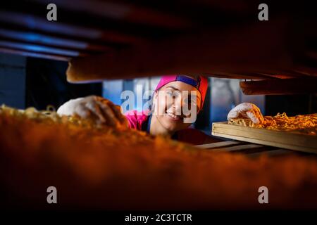 Das Mädchen arbeitet an der Herstellung von Spaghetti. Nudeln machen. Pasta-Fabrik. Stockfoto