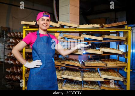 Arbeiter mit einer Schachtel Nudeln. Das Mädchen arbeitet an der Herstellung von Spaghetti. Nudeln machen. Pasta-Fabrik. Stockfoto