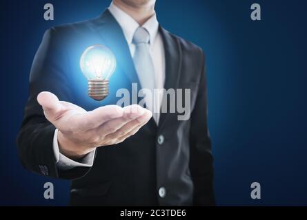 Geschäftsmann hält Glühbirne zur Hand. Neue Ideen, Innovation und Inspirationskonzept Stockfoto