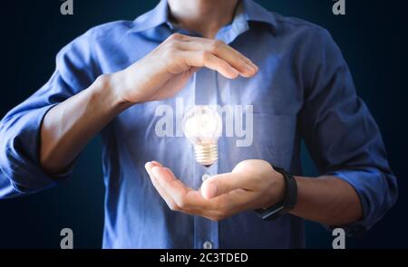 Geschäftsmann mit Glühbirne. Neue Ideen, Innovation und Energiesparen Stockfoto