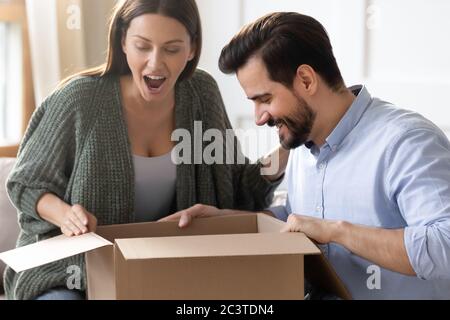 Aufgeregt überrascht Frau in Karton suchen, erhalten Paket Stockfoto