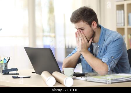 Besorgter Unternehmer Mann, der Laptop ansieht und sich im Büro beschwert Stockfoto