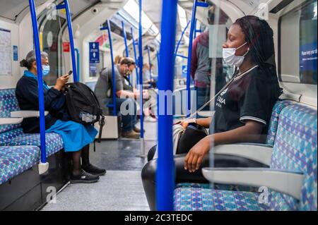 London, Großbritannien. Juni 2020. Einige Leute ignorieren weiterhin die Anweisung, Maske zu tragen oder wissen nicht, wie sie zu tragen sind - Passagierzahlen bleiben dramatisch unten auf der Röhre, sogar während der Hauptverkehrszeit nach der weiteren Lockerung der Regierungsführung. Wer reist, trägt fast alle Masken, nachdem sie im öffentlichen Verkehr obligatorisch werden. Die „Sperre“ für den Coronavirus (Covid 19) Ausbruch in London geht weiter. Kredit: Guy Bell/Alamy Live Nachrichten Stockfoto