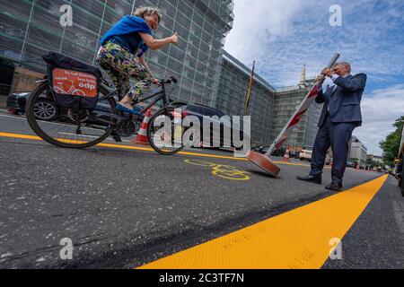 München, Deutschland. Juni 2020. Dieter Reiter, Oberbürgermeister von München, eröffnet in der Elisenstraße die erste Pop-up-Fahrradstraße und rollt einen Poller weg. Sonja Haider, ödp-Stadträtin im Münchner Rathaus, ist eine der ersten Radfahrerinnen, die mit Daumen nach oben auf die Fahrbahn fährt. Als eine von sechs Maßnahmen für mehr Sicherheit für Radfahrer während der Corona-Pandemie werden in der Elisenstraße zwischen Lenbachplatz und Dachauer Straße temporäre Radwege markiert. Quelle: Peter Kneffel/dpa/Alamy Live News Stockfoto