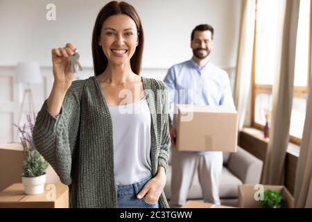 Lächelnde junge Frau zufriedene Kunden zeigen Schlüssel, Tag bewegen Stockfoto