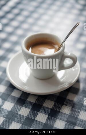 Single Italian Espresso auf karierter blau-weißer Tischdecke Stockfoto