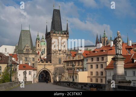 Brückenkopf der Karlsbrücke mit gotischem Tor und Türmen. Die Nikolaikirche und die Prager Burg sind in der Ferne sichtbar. Stockfoto