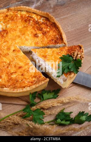 Hausgemachte französische Torte mit Champignons und Käse auf rustikalem Holzhintergrund. Köstliche Pilzpastete und Käsefüllung. Stockfoto