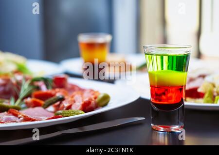 Bunte mexikanische Shots für Party im Restaurant.Spiced Gold Rum in Schnapsgläser zum Abendessen in der Bar serviert.Genießen Sie mehrfarbige alkoholische Getränke in Litt Stockfoto