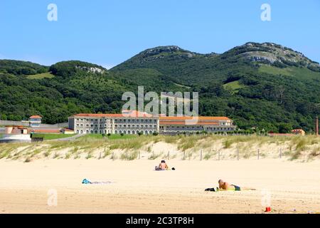 Ruhige Strandszene mit dem Gefängnis in Santona Centro Penitenciario de El Dueso Santona Cantabria Spanien Stockfoto