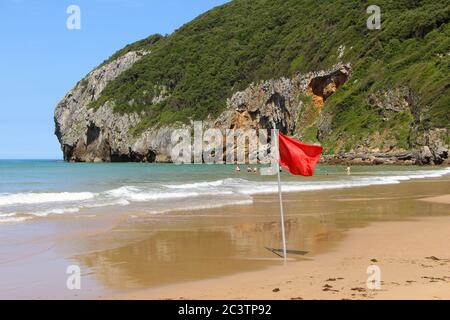 Ruhige Strandszene an einem windigen Juni Nachmittag mit einem Rote Warnflagge Santona Cantabria Spanien Stockfoto